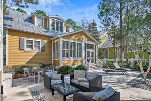 A house with a patio area featuring outdoor furniture and a grill. - WaterColor Escape |Bring the Whole Family—Pups Included! Sleeps 8 (Santa Rosa Beach)