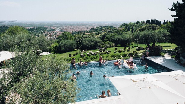 Ein Pool, umgeben von üppiger Vegetation, mit Blick auf eine entfernte Skyline.