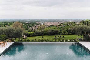 Ein Pool mit Blick auf eine Stadtlandschaft und Grünflächen.
