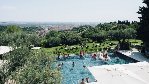 Ein Pool, umgeben von üppiger Vegetation, mit Blick auf eine entfernte Skyline.