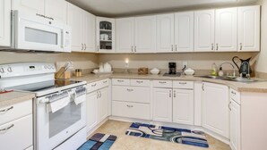 A kitchen with white cabinets, a microwave, an oven, and a sink. - Cozy Jacksonville Home ~ 12 Mi to Downtown! (Jacksonville)