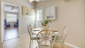 A dining area with a round table, white chairs, a ceiling fan, and a painting on the wall. - Cozy Jacksonville Home ~ 12 Mi to Downtown! (Jacksonville)