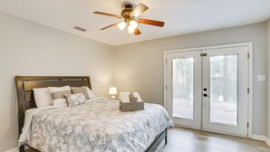A bedroom with a bed, a ceiling fan, a window, and a door. - Updated Tallahassee Townhome: 3 Mi to Downtown! (Tallahassee)
