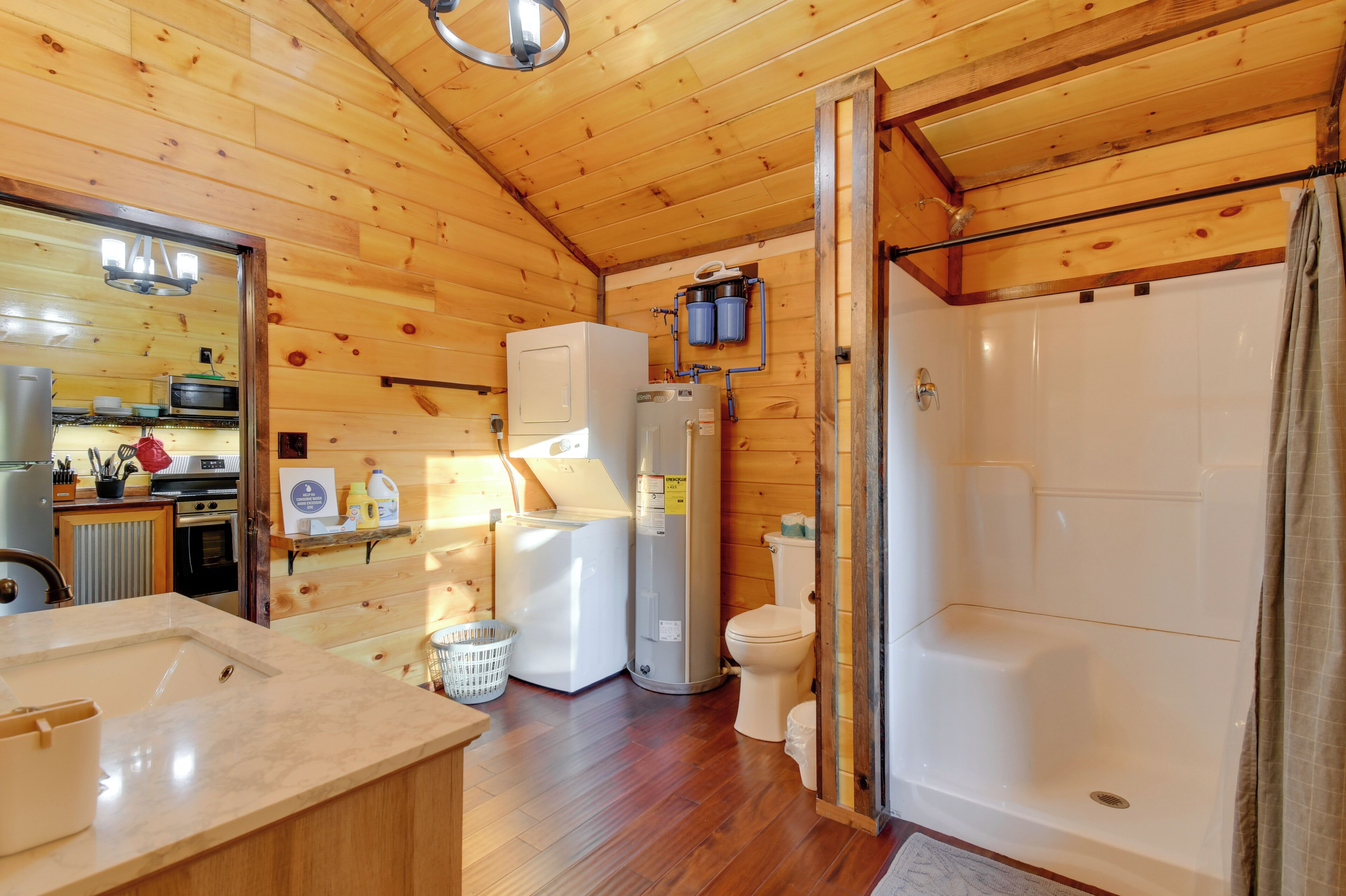 Eine Holzhütte mit Küche, Kühlschrank, Waschmaschine, Toilette und Dusche.