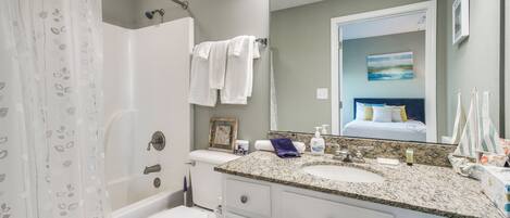 A bathroom with a bathtub, toilet, and sink.