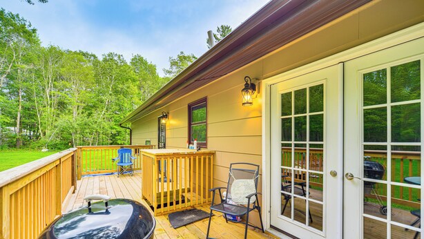 A deck with a barbecue grill, outdoor furniture, and a wooden fence. - Hayward Home w/ Private Deck, Fire Pit & Kayak! (Hayward)