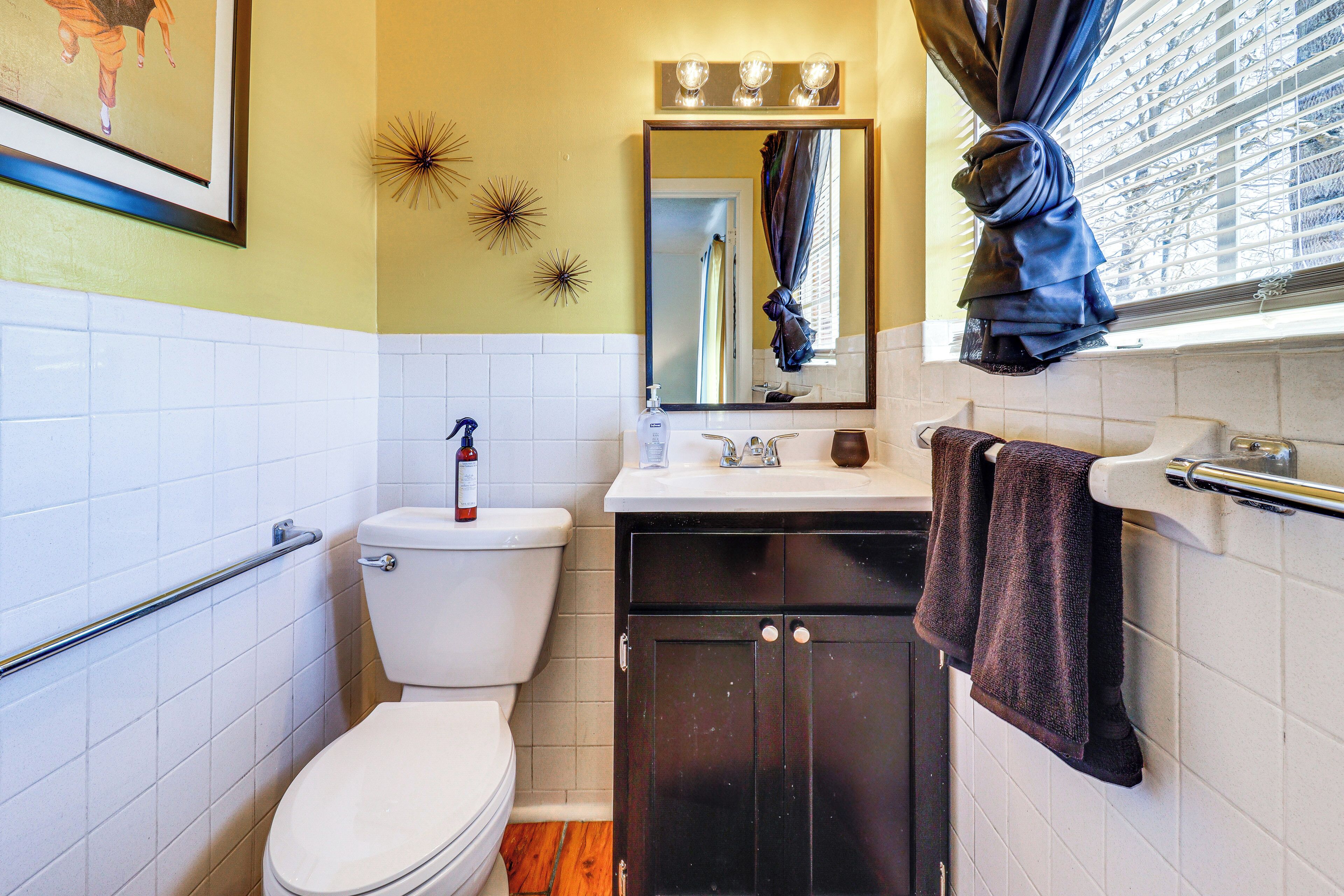 A bathroom with a toilet, sink, and cabinet.