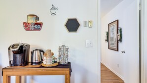 A coffee station with a coffee maker, a kettle, and a stack of cups on a wooden table. - Peaceful Trenton Home w/ Patio Near Hiking! (Trenton)