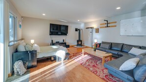 A modern living room with a sofa, a coffee table, a TV, and a fireplace. - Quaint Mount Vernon Studio Rental w/ Big Lake View (Mount Vernon)