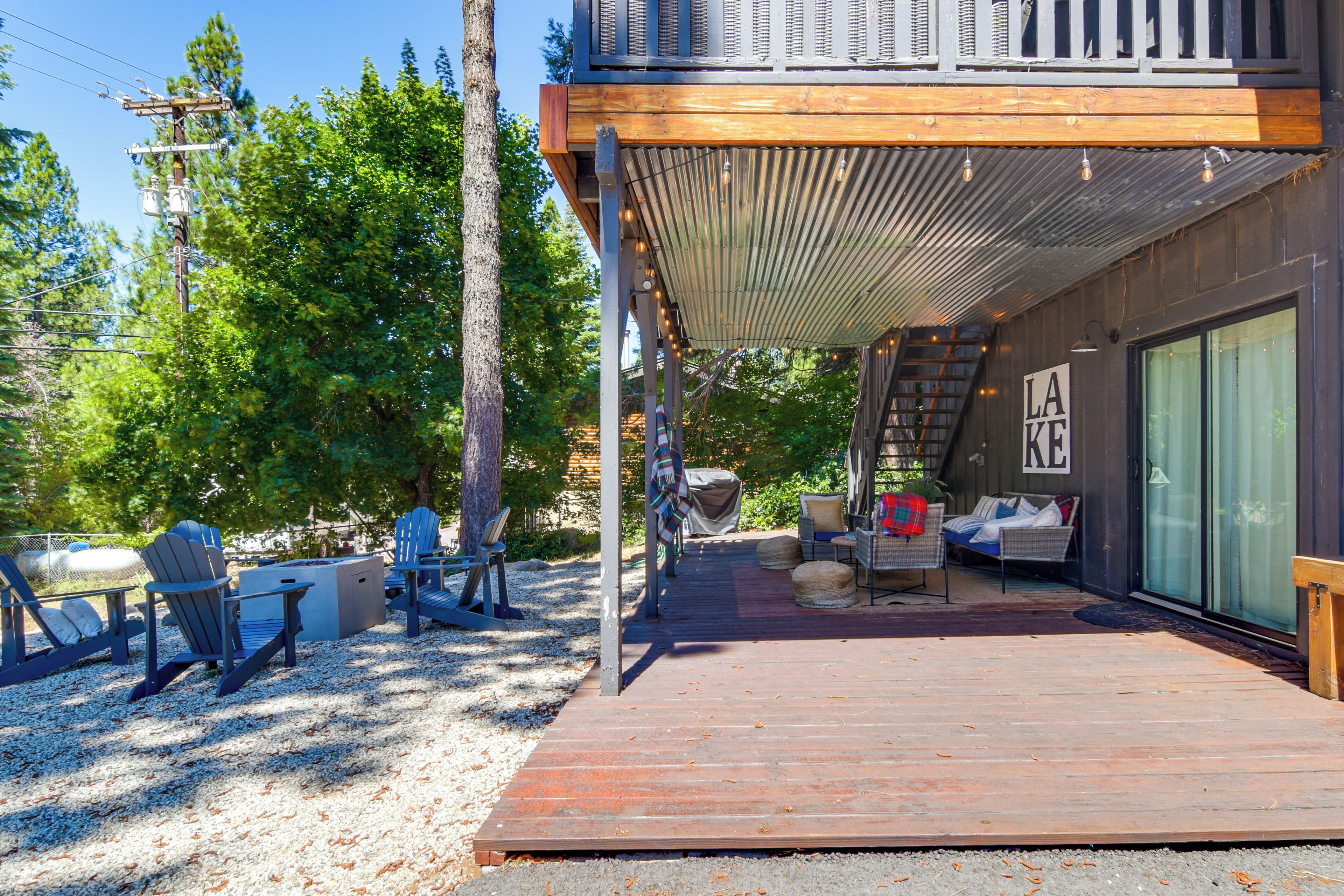 A deck with outdoor seating, a covered area, and a sign reading 'LAKE'.