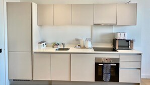 Cozinha moderna com forno embutido, micro-ondas e torradeira.