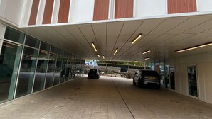 Um edifício moderno com galeria coberta e portas de vidro.