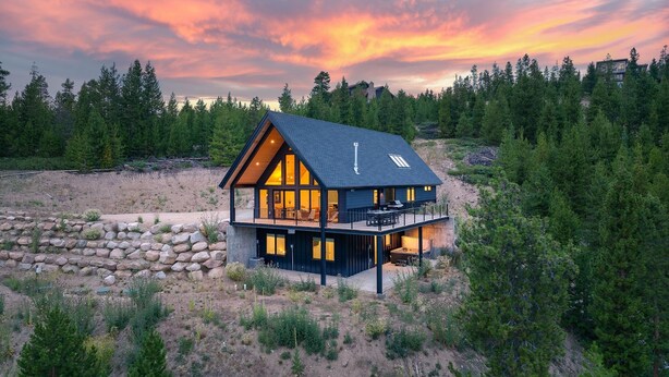 A modern house with a large balcony, surrounded by trees and a stone wall. - Mountain Vista 3 Bedroom Chalet by RedAwning (Tabernash)