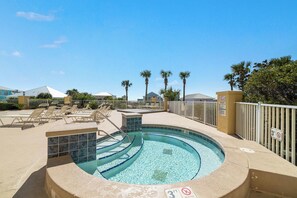 A pool area with lounge chairs, a hot tub, and a fenced pool deck. - Top-Floor 2BR/2BA Condo with Stunning Gulf Views | Sleeps 6 (Gulf Shores)