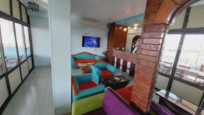 Een modern interieur met een zithoek, inclusief kleurrijke banken en een accentmuur van baksteen.