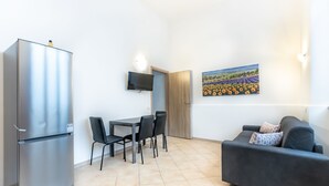 A compact living space with a kitchenette, a dining area, and a sofa. - Alessia's Flat- Torretta (Bergamo)