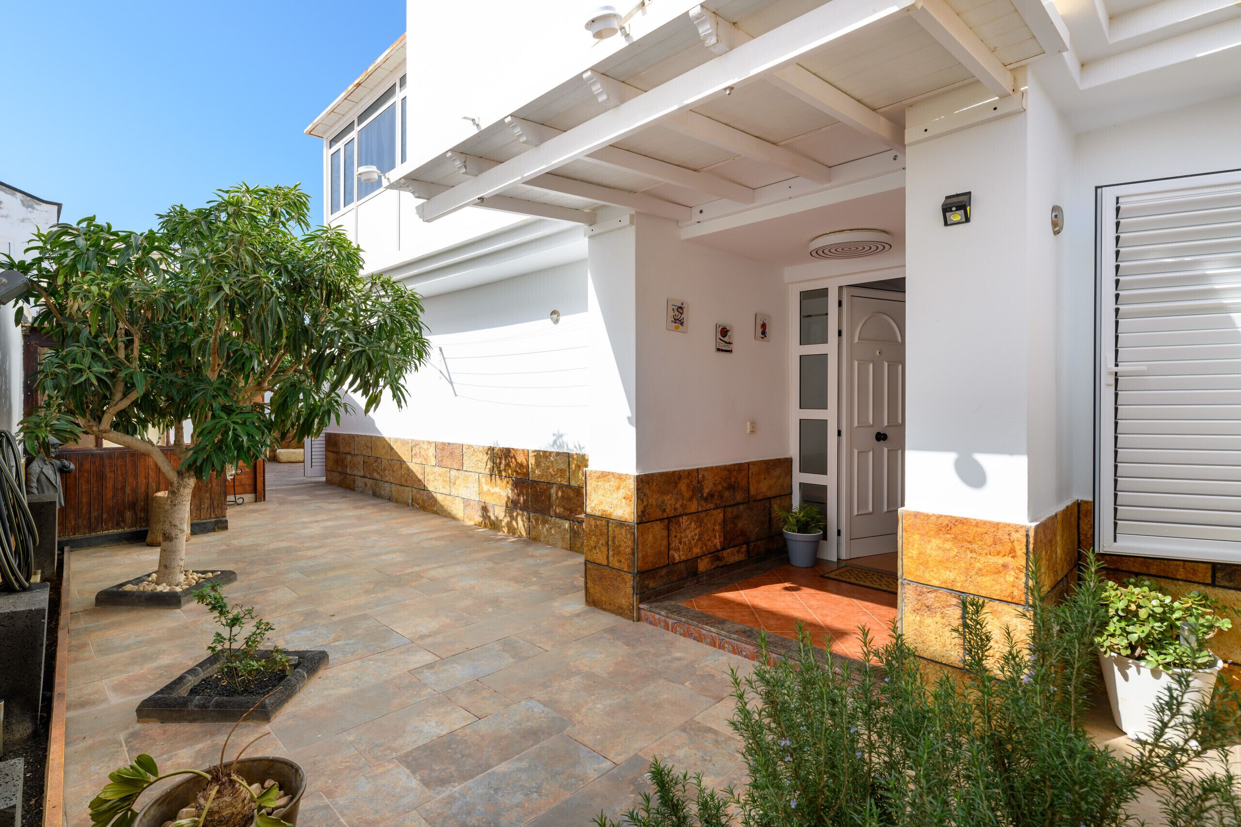 A house with a covered patio, a door, and a garage.