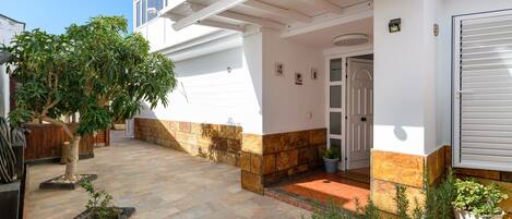 A house with a covered patio, a door, and a garage.