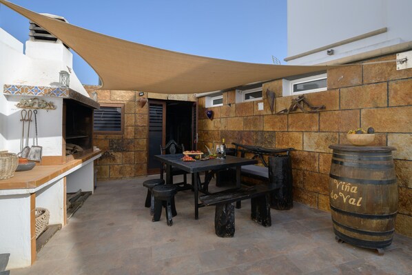 Une terrasse extérieure avec une table, des chaises et un tonneau portant l’inscription « Vina do Val ».