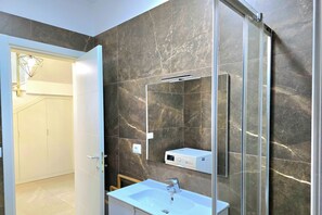 A modern bathroom with a large mirror, a sink, and a shower area. - Lalzit Bay Dream Villa (Ishëm)