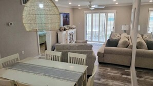 Una sala de estar con una mesa de comedor, sofá y televisor.