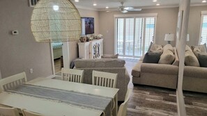 A living room with a dining table, sofa, and a television.