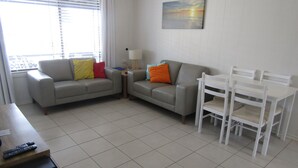 A living room with two sofas, a table, and chairs.