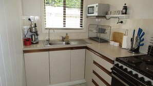 A compact kitchen with a sink, a microwave, and a stove.