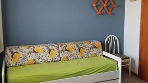 Une pièce comprenant un lit, une chaise et un élément décoratif fixé au mur.