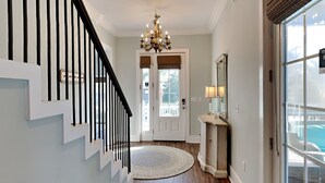 Un escalier avec des rampes noires menant à une porte dotée d’une fenêtre.