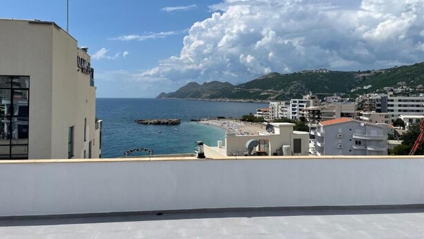 A coastal cityscape with a view of the sea, buildings, and a beach. - Senator Suites - Sea View - Dobra Voda (Bar)