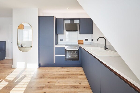 A modern kitchen with built-in appliances, a large window, and a wooden floor. - Host & Stay | Apartment 4, Fourth Avenue (York)