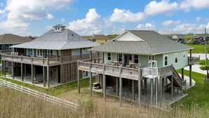 Ein zweigeschossiges Haus mit Balkon und überdachter Veranda.