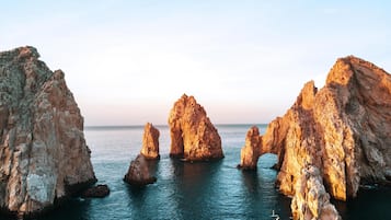Un paisaje costero con grandes formaciones rocosas y mar tranquilo.