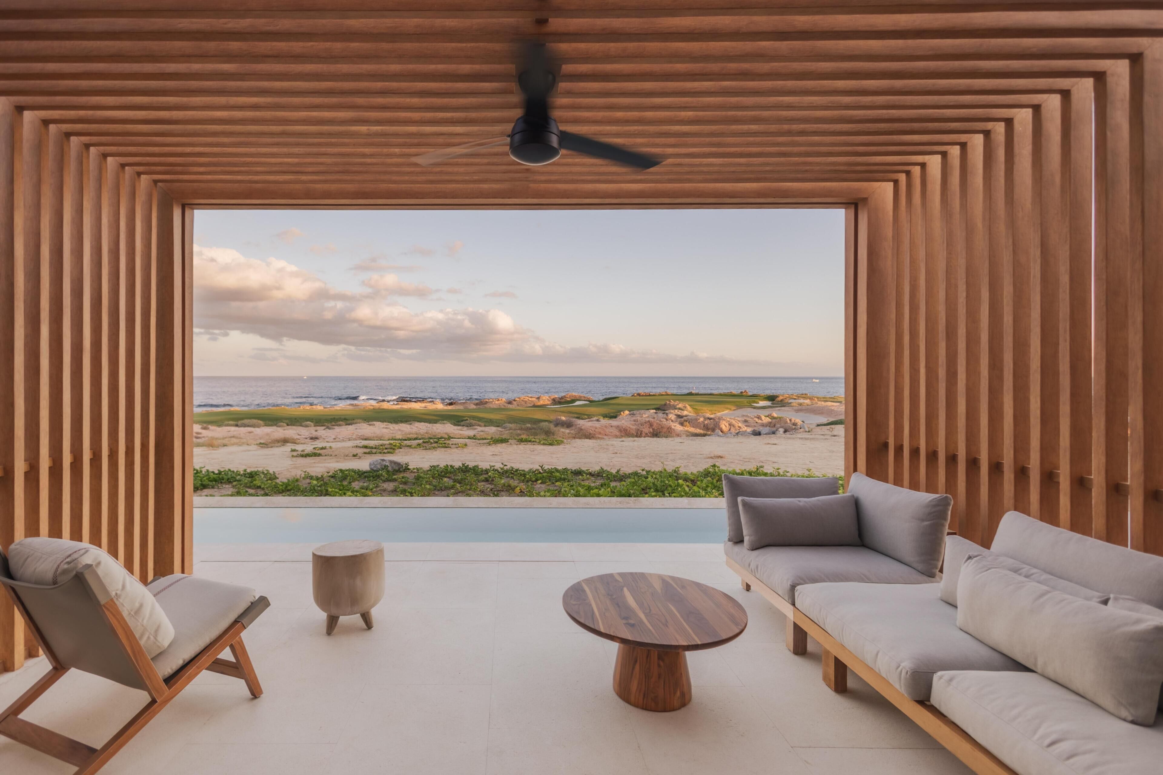 Un intérieur moderne avec vue sur une plage et l’océan.