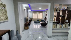 A modern living room with a sofa, coffee table, and bookshelves.