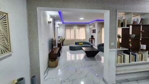 A modern living room with a marble floor, a sofa, a coffee table, and a bookshelf.