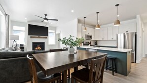 Una cocina moderna con armarios blancos, una isla central e iluminación colgante.
