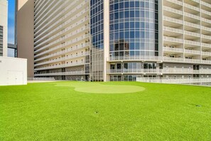 Un bâtiment moderne doté de nombreux balcons et d’une pelouse bien entretenue.