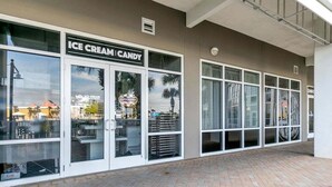 A storefront with a sign reading "ICE CREAM CANDY" and large windows. - Ocean Paradise 1425-Ocean Views-Sleeps 7 (Panama City Beach)