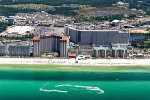 Ein Küstenhotelkomplex mit mehreren Hochhäusern, einem Strand und einer Marina.