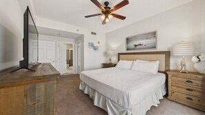 A bedroom with a bed, bedside tables, a ceiling fan, and a television. - Ocean Paradise 1425-Ocean Views-Sleeps 7 (Panama City Beach)