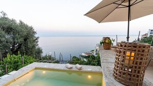 A rooftop pool with a view of the sea, a wooden lantern, and a wicker basket with fruits. - AMORE RENTALS - Villa Margherita with Sea View and Swimming Pool (Amalfi)