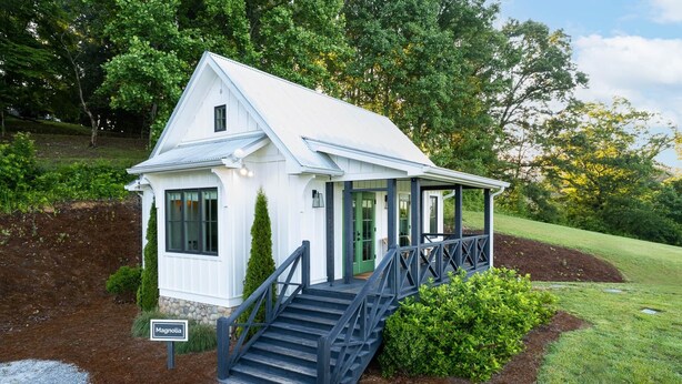 A small white building with a covered porch and a staircase leading up to it. - Magnolia Cottage at Julep Farms (Dillard)
