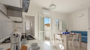 Une cuisine moderne équipée d’une cuisinière à gaz, d’une machine à café et d’un coin repas avec une table et des chaises.