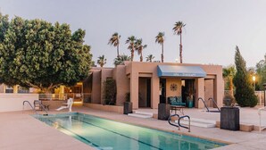 Edificio de terapias de SPA con piscina, palmeras y cielo despejado.