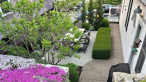 A stone staircase leading to a covered area with a seating area and string lights above.