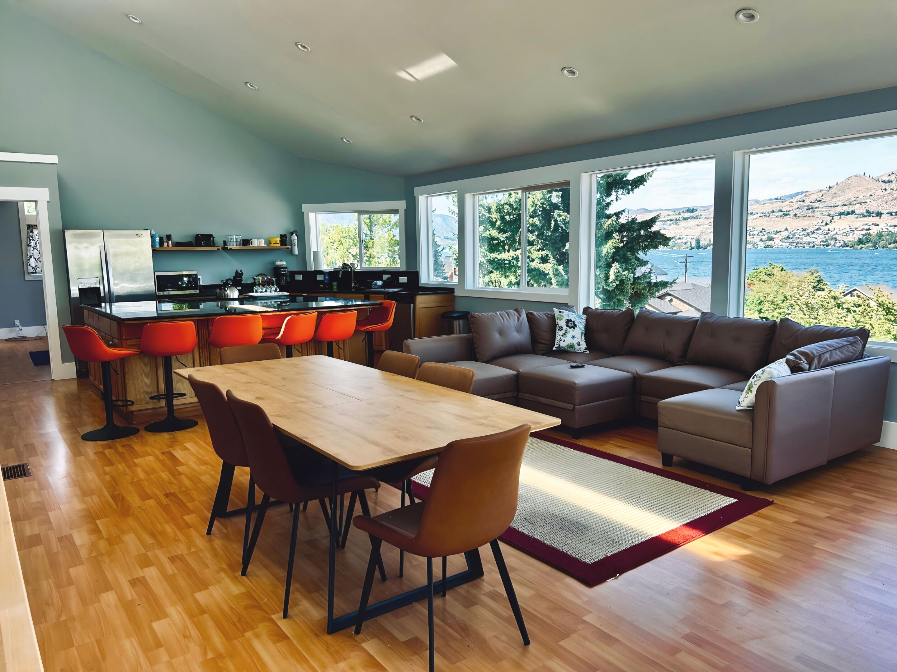 Un espacio moderno para vivir con cocina, comedor y zona de estar con vistas al agua y las colinas.