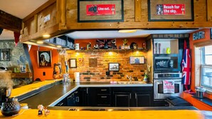 A kitchen with a brick wall, a bar area, and a flag.