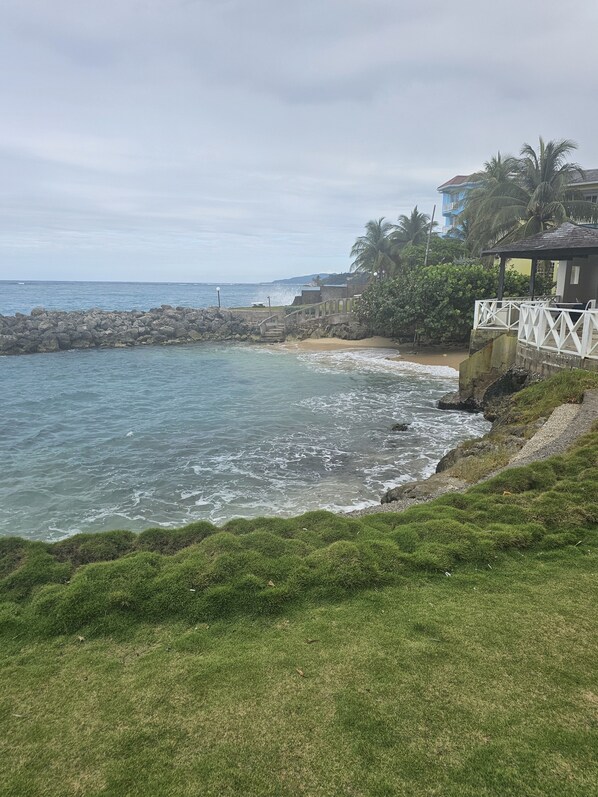 Privat strand, hvit sand, solsenger og strandhåndklær
